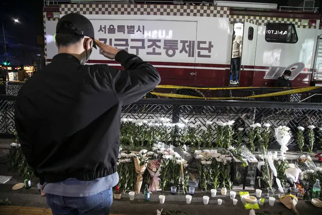 A man pays tribute by saluting at the temporary shrine next to the accident site in Itaewon in Seoul, South Korea on October 30, 2022. (Photo by Jean Chung for The Washington Post)