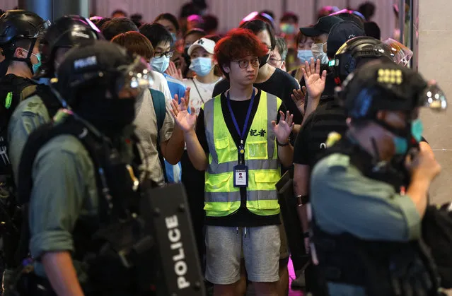 A reporter (C) raises his hands as he is being detained with protesters by police offices during a rally against a new national security law in Causeway Bay on the 23rd anniversary of the establishment of the Hong Kong Special Administrative Region in Hong Kong, China, 01 July 2020. Chinese President Xi Jinping has signed into law the national security legislation Beijing has tailor-made for Hong Kong, prohibiting acts of secession, subversion, terrorism and collusion with foreign forces to endanger national security. (Photo by Jerome Favre/EPA/EFE)