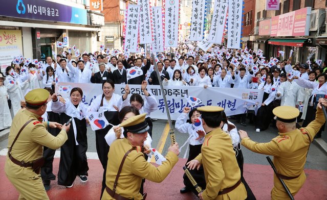 People clad in traditional costumes clash with others portraying Japanese police officers in Busan, South Korea, 11 March 2025, reenacting the independence movement in 1919, which students of Busanjin Ilshin Girls' School led as part of the popular movement the same year that protested for independence from Japan's colonial rule of the Korean Peninsula. (Photo by Yonhap/EPA/EFE)