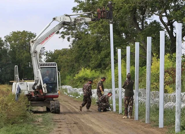 Soldiers build a barbed wire fence at the Hungary-Croatia border near Sarok, Hungary, September 20, 2015. (Photo by Bernadett Szabo/Reuters)