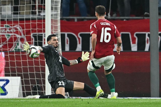 Turkey's goalkeeper #23 Ugurcan Cakir saves the ball against Hungary's midfielder #16 Daniel Gazdag during the UEFA Nations League A/B play-offs second leg football match Hungary v Turkey in Budapest, Hungary, on March 23, 2025. (Photo by Attila Kisbenedek/AFP Photo)