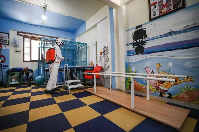 A member of the Syrian Civil Defence, also known as the “White Helmets” disinfects a room at a physiotherapy centre in Syria's rebel-held northwestern city of Idlib, on July 11, 2020. A first case of coronavirus was recorded in northwest Syria on July 9, an opposition official said, reviving fears of disaster if the pandemic reached the rebel bastion's displacement camps. (Photo by Omar Haj Kadour/AFP Photo)
