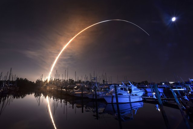 NASA's new moon rocket lifts off from the Kennedy Space Center in Cape Canaveral, Wednesday morning, November 16, 2022, as seen from Harbor town Marina on Merritt Island, Fla. The moon is visible in the sky. (Photo by Malcolm Denemark/Florida Today via AP Photo)