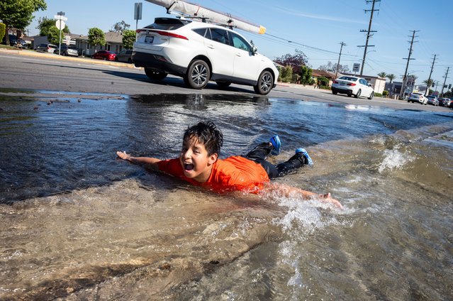 A boy plays in water from a broken fire hydrant in Rosemead, California on Saturday, May 10, 2025, seeking relief as spring heat breaks temperature records across the Southland. (Photo by Ringo Chiu/ZUMA Press Wire/Rex Features/Shutterstock)
