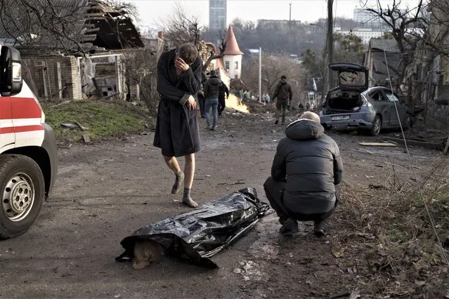A man reacts next to the body of his wife, killed during a Russian attack in Kyiv, Ukraine, Saturday, December 31, 2022. (Photo by Roman Hrytsyna/AP Photo)