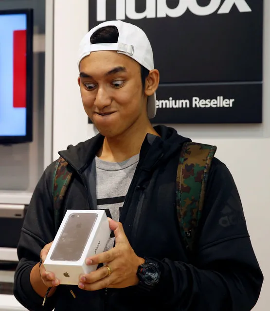Kent Lee, 20, the first customer in the queue, poses with his new iPhone 7 at an Apple reseller shop in Singapore September 16, 2016. (Photo by Edgar Su/Reuters)