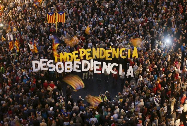 People protest against the decision by Catalonia's Supreme Court regarding the 9N consultation at Sant Jaume square in Barcelona, Spain, October 13, 2015. According to the demonstrators, they are protesting against Spain's decision to sue Catalan leader Artur Mas for defying a court ruling and holding a symbolic vote on the region's independence from the rest of the country on November 9, 2014. The words read, "Independence" and "Disobedience". (Photo by Albert Gea/Reuters)