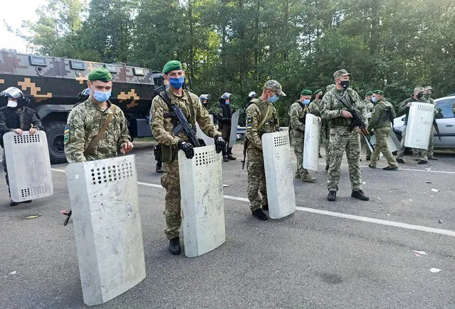 Ukrainian border guards block the road on the Belarus-Ukraine border, in Belarus, Tuesday, September 15, 2020. About 700 Jewish pilgrims are stuck on Belarus' border due to coroavirus restrictions that bar them from entering Ukraine. Thousands of pilgrims visit the city each September for Rosh Hashana, the Jewish new year. However, Ukraine closed its borders in late August amid a surge in COVID-19 infections. (Photo by TUT.by via AP Photo)