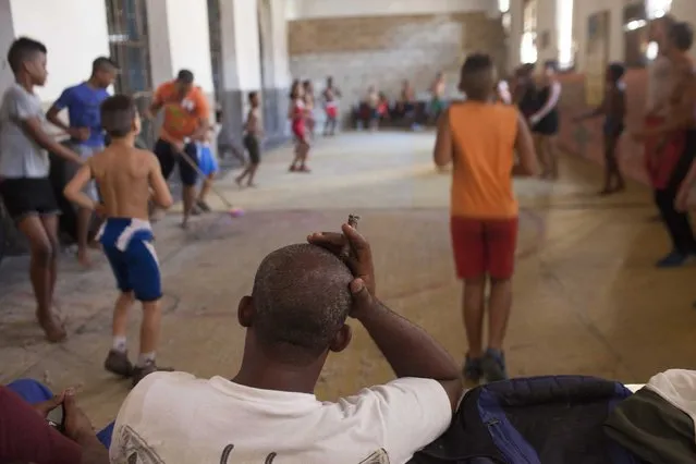 Wrestling teacher Esteban Quintana, 43, smokes a cigar during a training session in downtown Havana, October 30, 2014. (Photo by Alexandre Meneghini/Reuters)