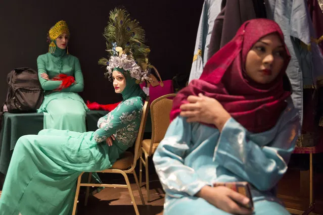 Models wear creations from the Calvin Thoo collection as they wait backstage during the Islamic Fashion Festival in Kuala Lumpur, Malaysia on Tuesday, November 18, 2014. (Photo by Vincent Thian/AP Photo)