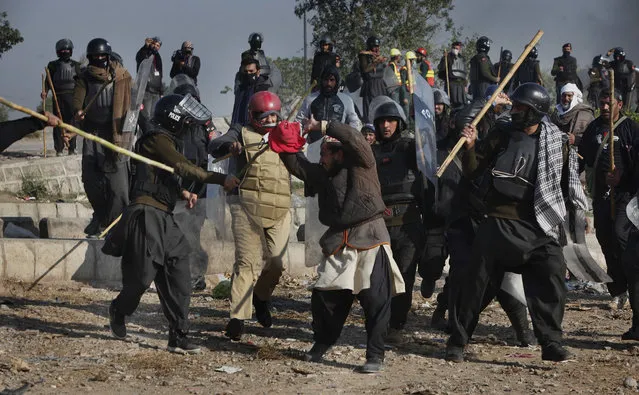 Pakistani police officers beat a protester during a clash in Islamabad, Pakistan, Saturday, November 25, 2017. Pakistani police have launched an operation to clear an intersection linking capital Islamabad with the garrison city of Rawalpindi where an Islamist group's supporters have camped out for the last 20 days. (Photo by Anjum Naveed/AP Photo)