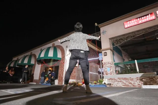 People stand outside the entrance of the Star Ballroom Dance Studio after a mass shooting during Chinese Lunar New Year celebrations in Monterey Park, California on January 23, 2023. (Photo by David Swanson/Reuters)