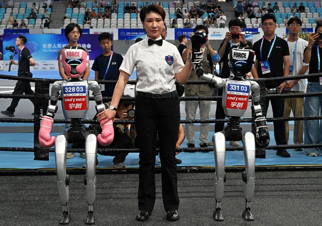 A referee announces the winner in the free combat style event during the World Humanoid Robot Games in Beijing on August 15, 2025. (Photo by Adek Berry/AFP Photo)