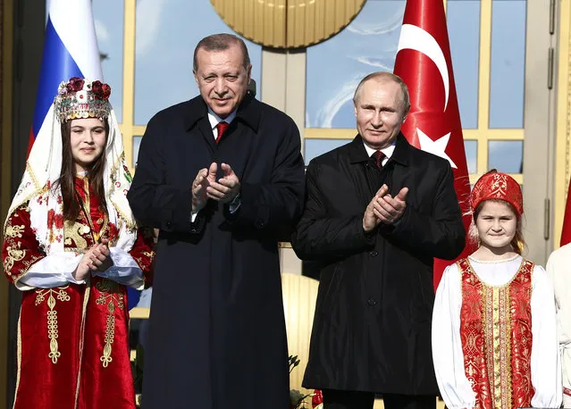 Turkey's President Recep Tayyip Erdogan centre left, and Russia's President Vladimir Putin, centre right, applaud during a welcome ceremony, in Ankara, Turkey, Tuesday, April 3, 2018. Turkey and Russia have put aside their traditional rivalries and differences on regional issues, to forge closer ties. (Photo by Burhan Ozbilici/AP Photo)