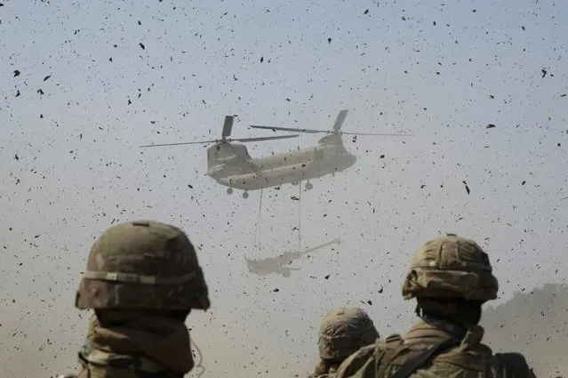 A U.S Army CH-47 Chinook helicopter transports a M777 howitzer during a joint military drill between South Korea and the United States at Rodriguez Live Fire Complex in Pocheon, South Korea, Sunday, March 19, 2023. North Korea launched a short-range ballistic missile toward the sea on Sunday, its neighbors said, ramping up testing activities in response to U.S.-South Korean military drills that it views as an invasion rehearsal. (Photo by Ahn Young-joon/AP Photo)