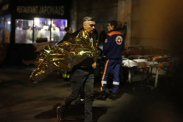 A victim walks outside the Bataclan theater in Paris, November 13, 2015. (Photo by Jerome Delay/AP Photo)