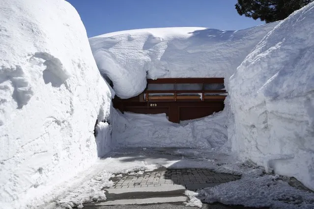 A house is covered with snow after a recent storm brought 30 inches of snow in less than 24 hours earlier in the week, in Mammoth Lakes, California, USA, 01 April 2023. California's Mammoth Mountain shattered its all-time snowfall record earlier this week, with more than 700 inches of snow so far this season, as reported by UC Berkeley Snow Lab. The state's snowpack has also reached an all-time high due to 17 atmospheric rivers that have been hitting the state since December, after years of drought. (Photo by Caroline Brehman/EPA)