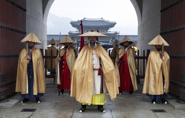 South Korean officials wearing a royal guard raincoat uniform, stand before the Royal Palace gates at the Gyeongbokgung Palace in Seoul, South Korea, 05 October 2025. Chuseok, one of Korea's major traditional holidays, falls on 06 October 2025, with the holiday period extending from 03 to 12 October. Every year, many Koreans travel to their hometowns to visit family and honor their ancestors during Chuseok. (Photo by Jeon Heon-Kyun/EPA)