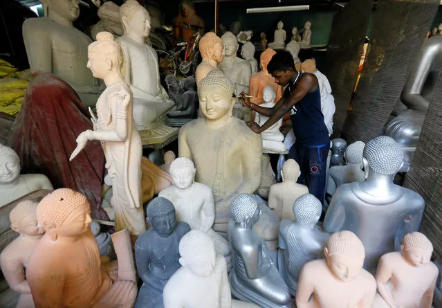 A man cleans a Buddha statue, intended for sale, before taking it to a paint room ahead of Vesak Day celebrations at a factory in Colombo, Sri Lanka April 27, 2018. (Photo by Dinuka Liyanawatte/Reuters)