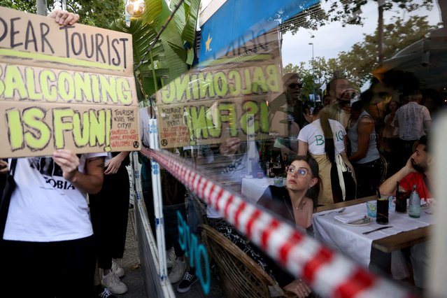 A tourist watches as demonstrators protest against mass tourism in Barcelona, Spain, July 6, 2024. The Catalan capital received more than 12 million tourists in 2023 and expects more in 2024. (Photo by Bruna Casas/Reuters)