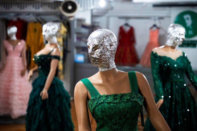 This photograph taken on July 22, 2024, shows veiled mannequins dressed in women's attire, at a shop in Kabul. In Afghanistan's capital, shop windows display dazzling ball gowns and three-piece wedding suits – with the face of each mannequin covered. The morality police have asked stores to hide the mannequins' faces and photographs of models, according to a clothes seller in Kabul. (Photo by Wakil Kohsar/AFP Photo)