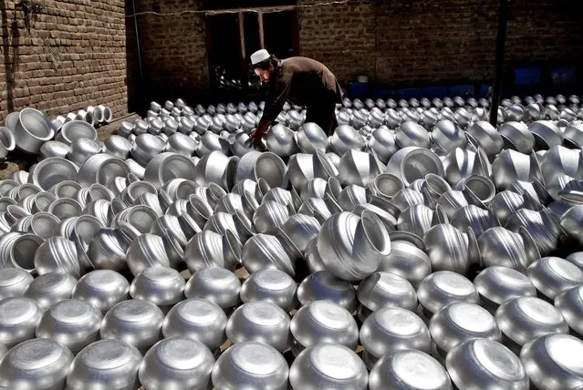 A laborer arranges pots at an aluminum factory in Jalalabad, Afghanistan, on June 5, 2013. Men working at the factory earn an average of $ 7.28 per day. (Photo by Rahmat Gul/Associated Press)