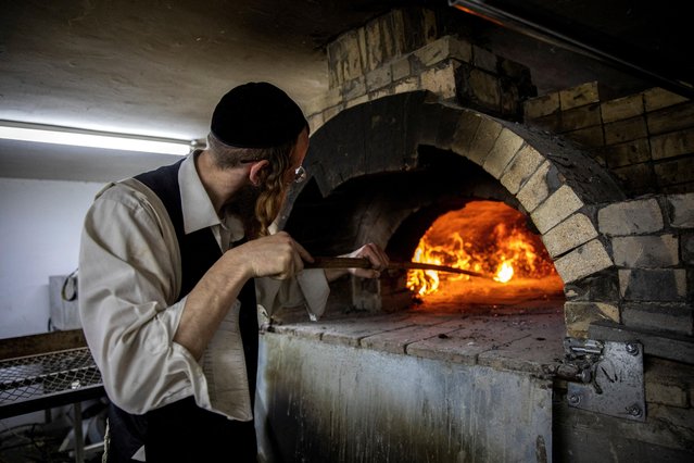 An Ultra Orthodox Jewish man prepares matza, a traditional unleavened bread eaten during the upcoming Jewish holiday of Passover, in Haifa, Israel, on April 3, 2023. (Photo by Shir Torem/Reuters)