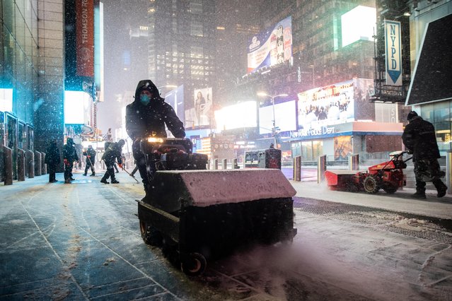 Worker clears snow as snow begins to fall in Times Square during a snow storm, during the coronavirus disease (COVID-19) pandemic in the Manhattan borough of New York City, New York, U.S., January 31, 2021. (Photo by Jeenah Moon/Reuters)