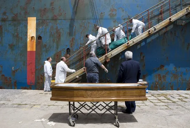 People carry the body of a dead migrant from a merchant ship as they arrive in the Sicilian harbour of Catania, southern Italy, May 5, 2015. (Photo by Antonio Parrinello/Reuters)