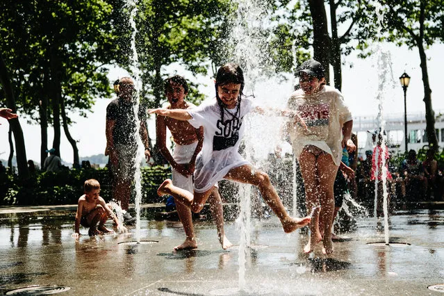 Children play in a water fountain in Battery Park, in New York, New York, USA, 02 July 2018. Temperatures in New York City are expected to reach highs of 96 degrees fahrenheit (35.5 Celsius) as the east coast of US is experiencing a heat wave. (Photo by Alba Vigaray/EPA/EFE)