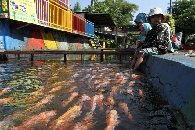 People visiting the Lepen Dam area, Gajah Wong River, Umbulharjo, Yogyakarta on May 30, 2023. The irrigation ditch of the Gajah Wong River, which is used to raise tilapia and koi by local residents and neatly arranged, is currently an alternative tourist destination in Yogyakarta. (Photo by Angga Budhiyanto/ZUMA Press Wire/Rex Features/Shutterstock)