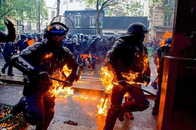 Incredible photo capture police offivers ON FIRE as they clash with protesters during a demonstration on May Day (Labour Day), to mark the international day of the workers in Paris, France on May 1, 2023. (Photo by Florian Poitout/AbacaPress/Splash News and Pictures)