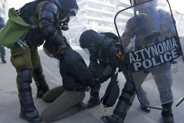 Riot police detain a man during clashes in the northern city of Thessaloniki, Greece, Thursday, March 11, 2021. (Photo by Giannis Papanikos/AP Photo)