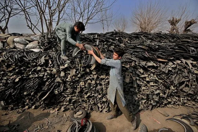 Laborers load pieces of used tyres at a used tire market to recycle in Peshawar, Pakistan, 15 February 2021. Laborers work on converting used vehicle tires into beautiful forms of household furniture such as armchairs, small tables, vases and baskets as a way to protect the surrounding environment. (Photo by Bilawal Arbab/EPA/EFE)