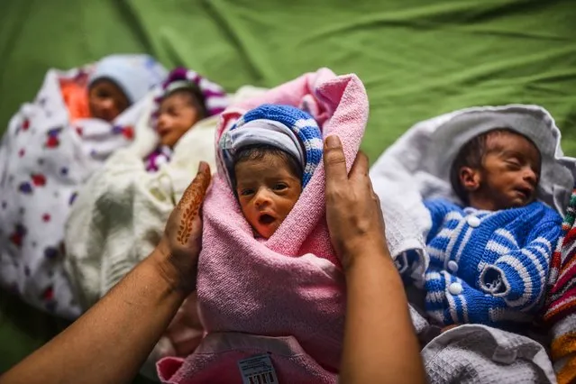 An Indian health worker takes care of newborn babies as they rest inside a ward at a government maternity hospital on World Population Day, in Chennai, India, 11 July 2023. World Population Day, established by the United Nations (UN), is observed every year on 11 July to raise awareness and educate individuals about global overpopulation issues and their impact on various aspects of human life. According to the United Nations (UN) population estimates, India has surpassed China to become the world's most populous country with more than 1.4 billion population in April 2023. The theme for World Population Day 2023 is “Unleashing the power of gender equality: Uplifting the voices of women and girls to unlock our world's infinite possibilities”. (Photo by Idrees Mohammed/EPA/EFE/Rex Features/Shutterstock)