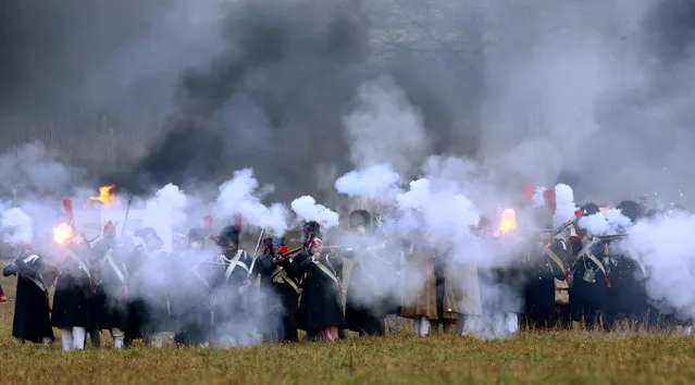 People dressed in the historic uniforms of the French army take part in a re-enactment of the 1812 Battle of Berezina, to mark the 204th anniversary of the battle, near the village of Bryli, Belarus, November 27, 2016. (Photo by Vasily Fedosenko/Reuters)