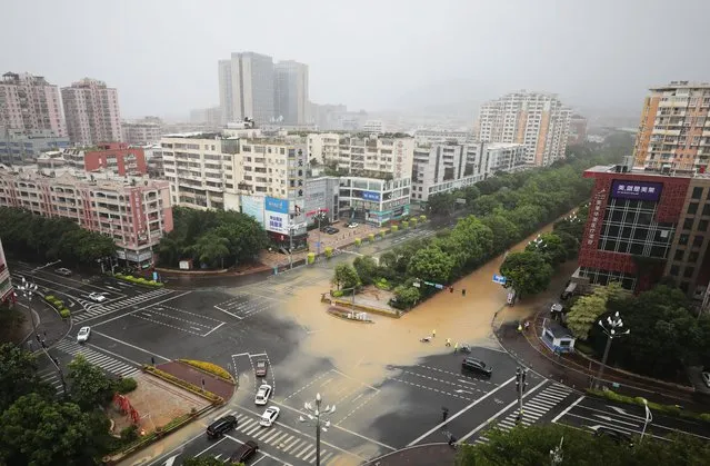 Traffic police cordon off a flooded area as typhoon Doksuri brings strong winds and gales on July 28, 2023 in Quanzhou, Fujian Province of China. (Photo by Shi Yong/VCG via Getty Images)