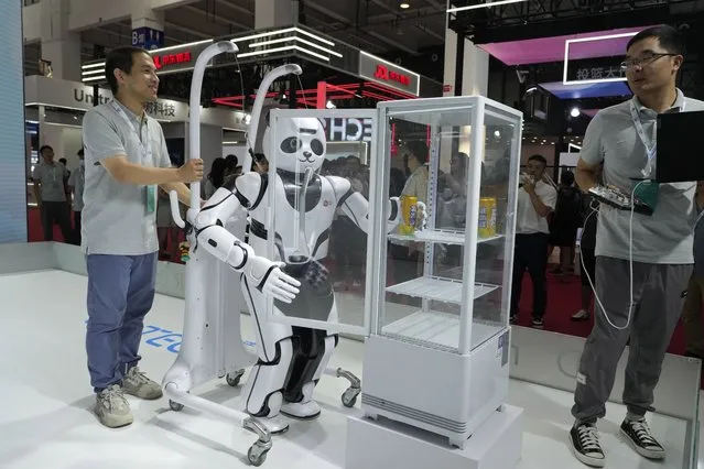 A panda shaped robot demonstrates its ability to grab a can of soda at the annual World Robot Conference at the Beijing Etrong International Exhibition and Convention Center in Beijing, Wednesday, August 16, 2023. (Photo by Ng Han Guan/AP Photo)