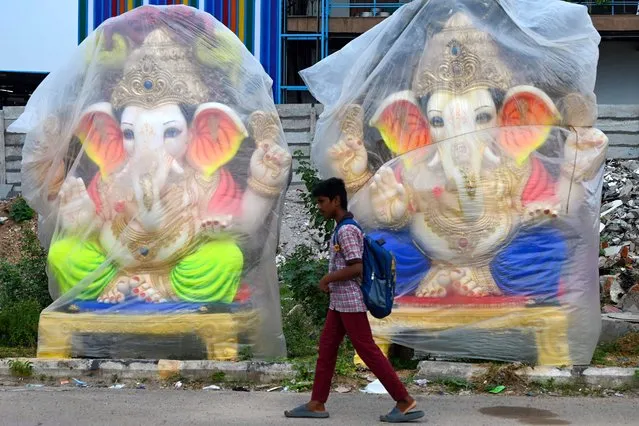 A boy walks past the idols of Hindu deity Ganesha along a road ahead of the Ganesh Chaturthi festival, on the outskirts of Hyderabad on August 18, 2023. (Photo by Noah Seelam/AFP Photo)