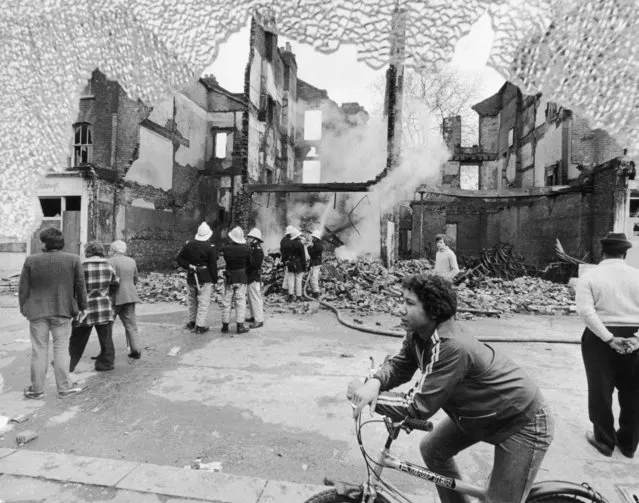 Firemen and onlookers beside a burnt-out building on the second day of riots in Brixton, South London, 13th April 1981.(Photo by David Levenson/Simon Dack/Keystone/Hulton Archive/Getty Images)