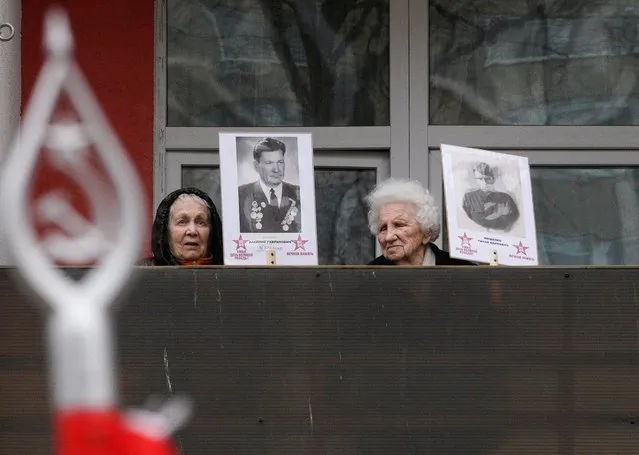 Participants hold portraits of Red Army soldiers on a balcony of a board and care home for veterans during the Immortal Regiment ceremony during the celebrations of Victory Day, which marks the 76th anniversary of the victory over Nazi Germany, in Kaliningrad, Russia on May 9, 2021. (Photo by Vitaly Nevar/Reuters)