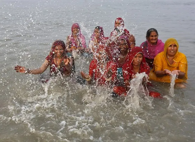 Hindu pilgrims take a dip at the confluence of the river Ganges and the Bay of Bengal, ahead of the "Makar Sankranti" festival at Sagar Island, south of Kolkata, India, January 13, 2016. (Photo by Rupak De Chowdhuri/Reuters)