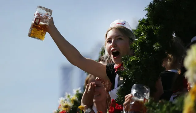 Waitresses wave with beer mugs during the horse coaches parade on the opening day of the 2023 Munich Oktoberfest on September 16, 2023 in Munich, Germany. This year's Oktoberfest will run through October 3 and is expected to draw millions of visitors. (Photo by Johannes Simon/Getty Images)