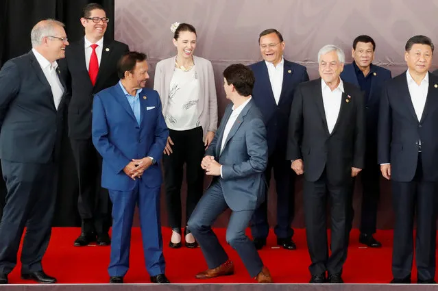 Canada's Prime Minister Justin Trudeau shares a joke about his height with New Zealand's Prime Minister Jacinda Ardern during a family photo at the APEC Summit in Port Moresby, Papua New Guinea on November 18, 2018. (Photo by David Gray/Reuters)