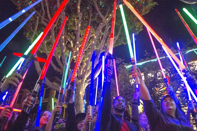 Fans of actress Carrie Fisher honored her death by pointing their lit “Star Wars” light sabers to the sky at 7 p.m. at Downtown Disney, Wednesday night, December 28, 2016, in Anaheim. (Photo by Mark Eades/The Orange County Register via AP Photo)