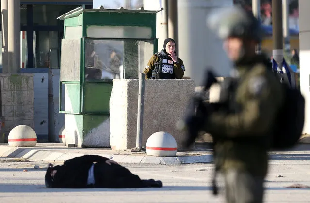 A Palestinian woman, who according to the Israeli police was shot and wounded after she attempted to stab Israeli officers, lies on the ground at Qalandiya checkpoint near the West Bank city of Ramallah December 30, 2016. (Photo by Mohamad Torokman/Reuters)