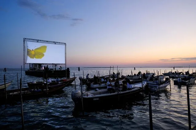 People on boats attend a movie screening at a float-in cinema during the “Floating Cinema – Unknown Waters” event, taking place on the waters of the Venetian lagoon, in Venice, Italy on August 25, 2022. (Photo by Manuel Silvestri/Reuters)