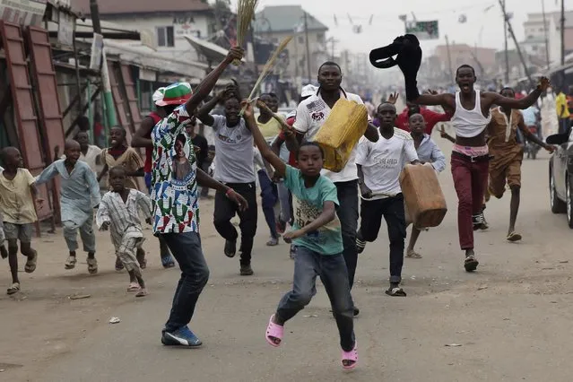 Residents celebrate the anticipated victory of Presidential candidate Muhammadu Buhari in Kaduna,  Nigeria Tuesday, March 31, 2015. (Photo by Jerome Delay/AP Photo)