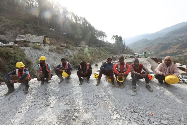 Fellow workers gather near the site of a tunnel collapse as they wait for instructions to take part in the rescue and relief operations, in Uttarkashi, India, 26 November 2023. Rescue and relief operations were underway as 40 workers remained trapped after an under-construction tunnel collapsed on 12 November 2023. The workers were expected to be rescued on 24 November but rescue operations were halted due to some technical glitch. (Photo by Harish Tyagi/EPA)