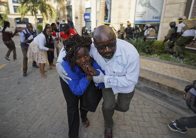 Civilians flee the scene at a hotel complex in Nairobi, Kenya Tuesday, January 15, 2019. Terrorists attacked an upscale hotel complex in Kenya's capital Tuesday, sending people fleeing in panic as explosions and heavy gunfire reverberated through the neighborhood. (Photo by Ben Curtis/AP Photo)